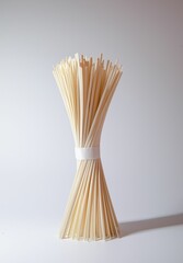 Vertical closeup of wooden bamboo sticks for skewer on a white background
