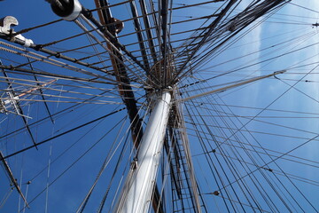 maritime or nautical scenery of an old large historic beautiful ship with all its masts against the blue sky in London, England