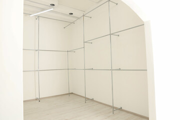 Metal pipes near white walls in empty office room. Interior design