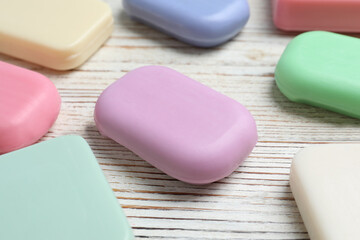 Many different soap bars on wooden table, closeup
