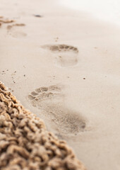 Footprints in the sand next to washed up fishing net.
Fußspuren im Sand neben angeschwemmten Fischernetz. 