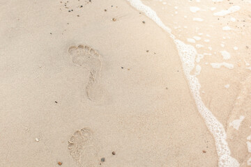Fototapeta na wymiar Footprints in the sand. Footprint on the shore. Fußspuren im Sand. Abdruck am Ufer.
