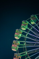 Giant ferris wheel with green lighting in An Exhibition indian Fair at night