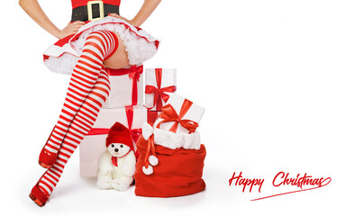 Sexy Christmas woman. Beautiful Mrs santa claus legs in striped stockings and high heels next to xmas gifts and happy Christmas inscription