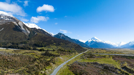 Alpine vista with blue sky as highway leading towards them, shot at Aoraki Mt Cook National Park, New Zealand