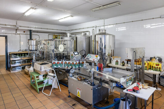 Huelva, Spain - December 4, 2022: Bottling and labeling machine inside of a modern olive oil mill. Extra virgin olive oil factory brand Olibeas in the village of Beas, Huelva, Andalusia, Spain