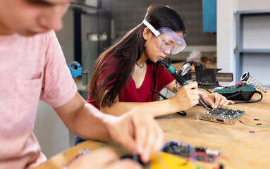 Young asian female student building robot in engineering class at high school. Education lifestyle...