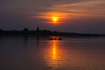 Naklejka premium the boat runs through th sunset in mekhong river sunset over the river