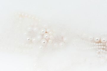 servant's pearl beads peek out of the foam.