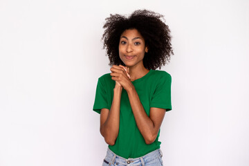 Fototapeta na wymiar Portrait of funny young woman expressing love and admiration over white background. African American lady wearing green T-shirt and jeans looking at camera and clasping hands. Admiration concept