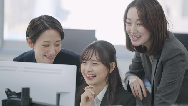 パソコンを見て話すビジネスウーマン（パソコン・チェック・確認・会話）