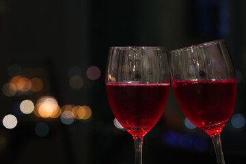 2 glasses of red wine with bokeh lights background. Romantic dinner dating at night. christmas celebrate concept.