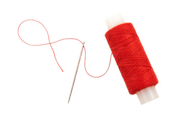 Needle with multi-colored threads on a white background. Eye of a needle close-up isolate