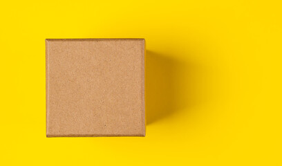 Brown craft paper or carton box with lid mock up on yellow background.