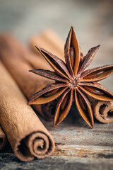 Star anise and cinnamon sticks close-up on a wooden background.