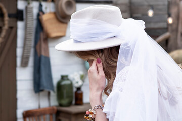 country bride in a white long dress and hat  in the village wedding, boho style.