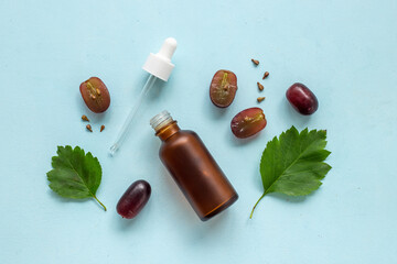 Bottle of grape seed essential oil with grapes. Eco cosmetic product