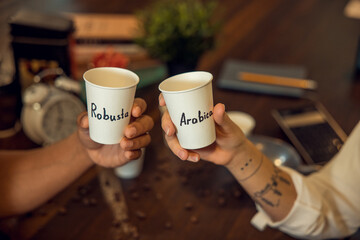 Biracial couple demonstrating caffeinated beverages before the camera