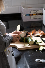 woman cutting vegetables on wooden board in kitchen
