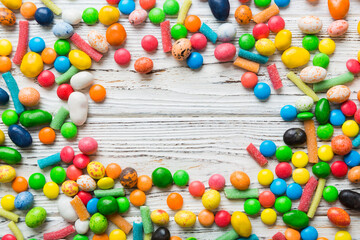 Mixed collection of colorful candy, on colored background. Flat lay, top view. frame of colorful chocolate coated candy