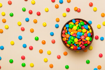 Multicolored candies in a bowl on a colored background. birthday and holiday concept. Top view with copy space