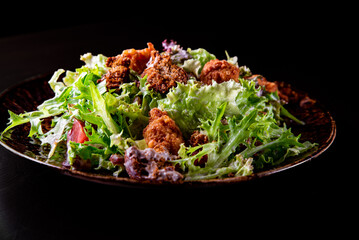 Caesar salad with croutons, cheese, eggs, tomatoes and grilled chicken on wooden table.