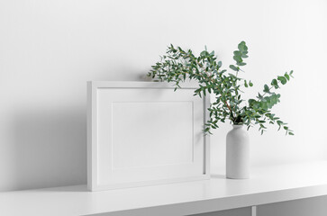 White picture frame mockup with fresh eucalyptus plant decor in vase