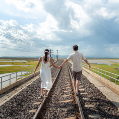 Couple hold the hands together to walk on railway, background for lover and couple life