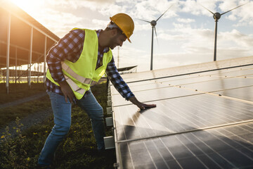 Man working for solar panels and wind turbines - Renewable energy concept - Soft focus on hand...