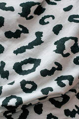 Texture, background, pattern. Cloth is white and black with a print of leopard spots