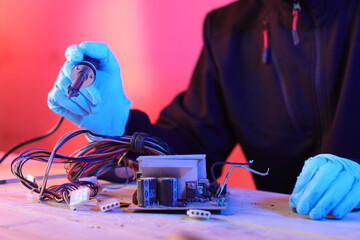 disassembly of a computer power supply on a table by a person