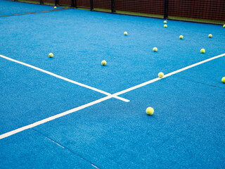 Tennis balls scattered randomly on the playground, selective focus, Paddle tennis balls on a paddle tennis court for background. Racket sport concept.
