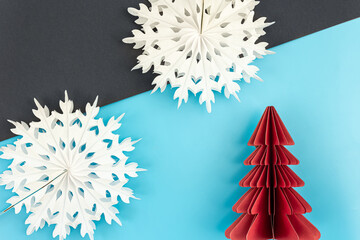 Christmas background with origami paper tree and snowflakes, flat lay.