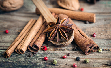 Composition with star anise and cinnamon sticks on a wooden background.