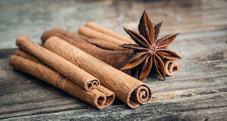 Star anise and cinnamon sticks close-up on a wooden background.