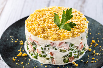 Russian salad or Olivier salad for Christmas dinner on wooden table