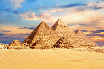 The Great Pyramids of Giza under a colorful desert sky, Egypt