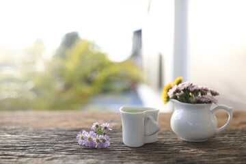 Tea cup on aster and chrysanthemum flowers on wooden table
