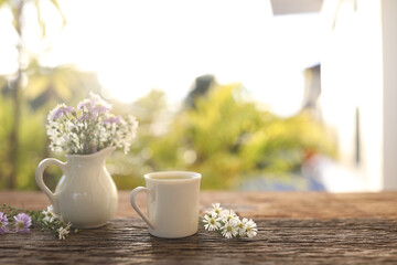Tea cup on aster flowers on wooden table