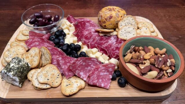 Charcuterie board with variety of meats, crackers, olives, nuts and cheese