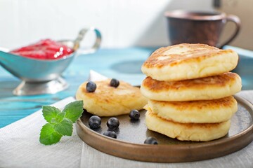 Cottage cheese fritters (cheesecake) on a blue plate. Selective focus.