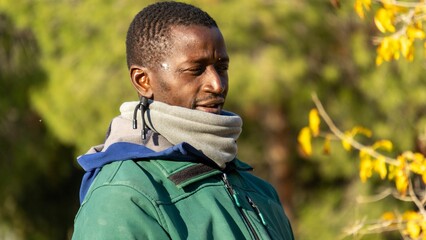Black African looking on a field against autumnal trees