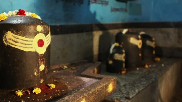 Closeup of historical lingam or shiv ling decorated with flowers