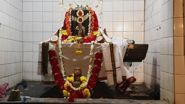 Closeup of historical lingam or shiv ling with garland and cloth