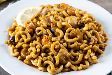 Traditional Spanish fideua on wooden table. Noodle paella 