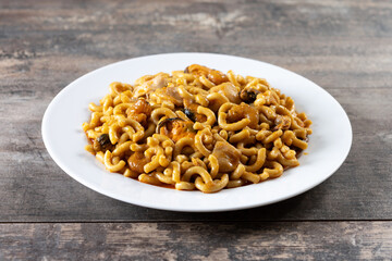 Traditional Spanish fideua on wooden table. Noodle paella 