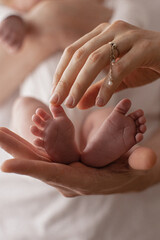 newborn baby feet on mom and dad hands. happy family concept