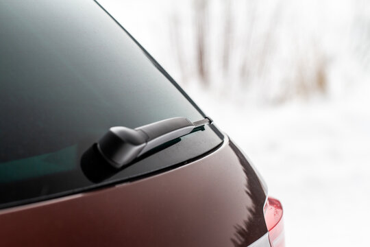 Winter back car window. A car wiper cleans the rear window.