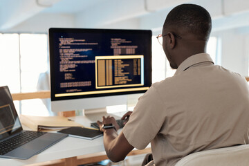 Fototapeta na wymiar Black software developer working on computer, testing code of new application