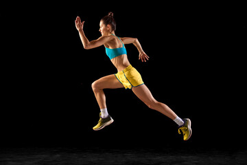 Female athlete in action. Young fitness sportive girl in sports uniform running, training isolated...
